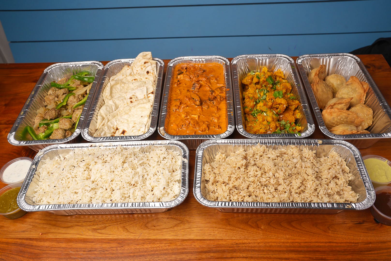 NaanStop fresh Indian food spread with naan, curries, and rice bowls